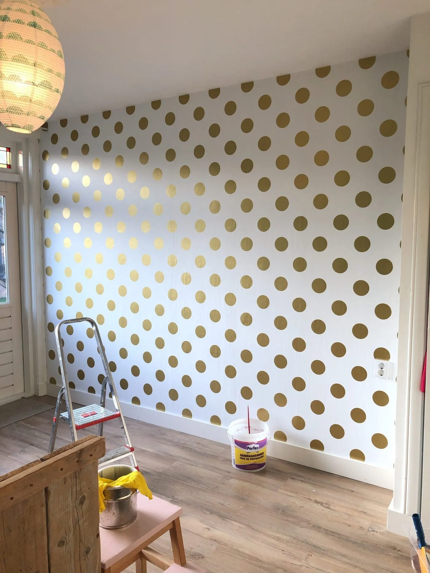 Wand met gouden stippen op een witte ondergrond