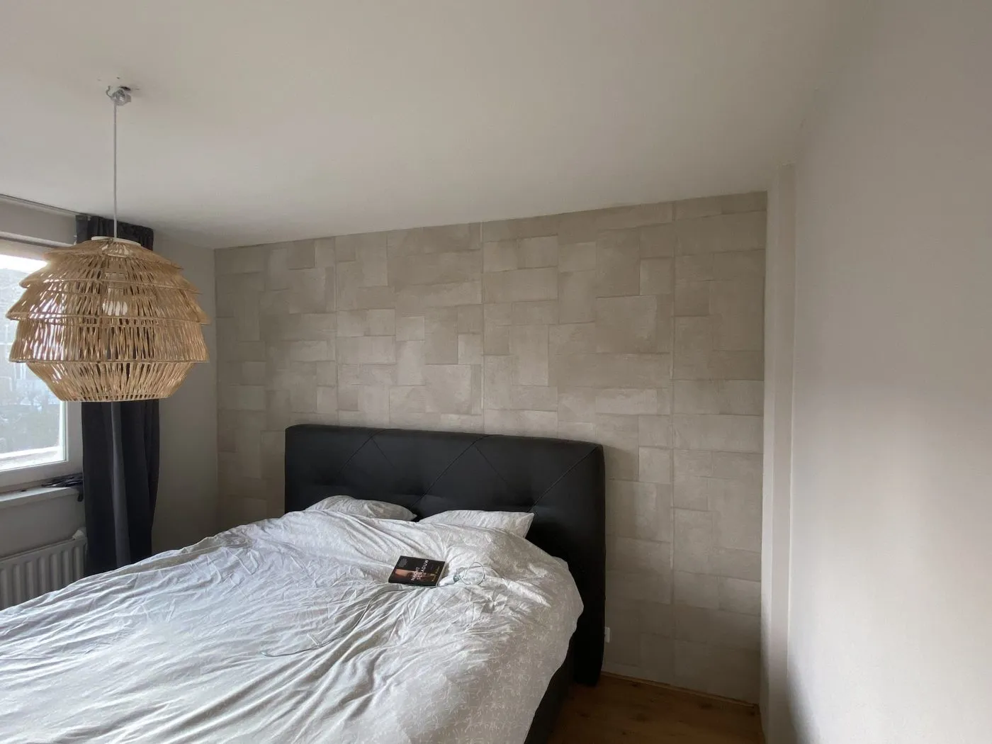 Behanger brengt geweven textielbehang droog aan op een egale wand.