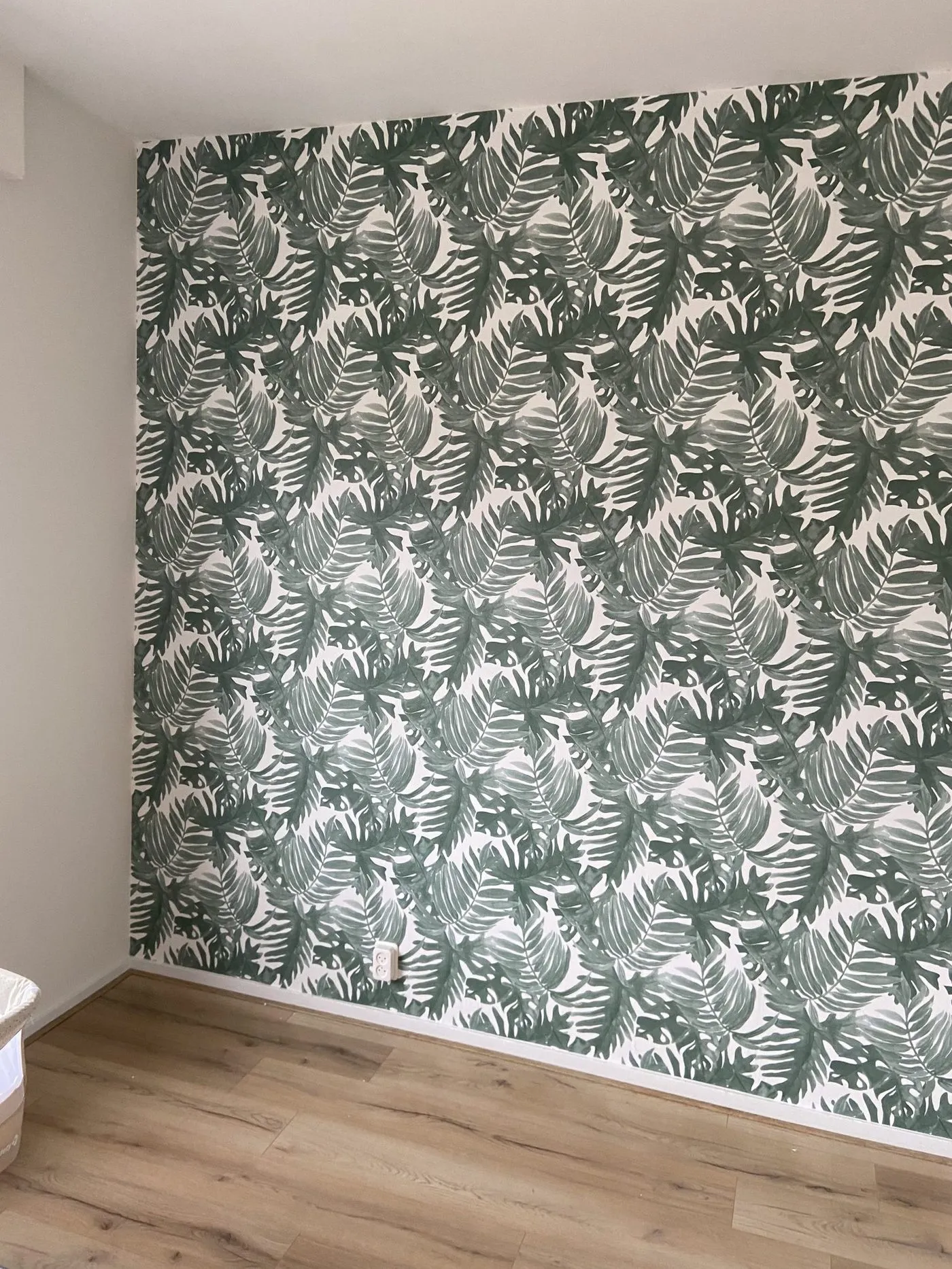 Strak gehangen behang in een woonkamer in Delft, patroon dat langs de wand op maat aansluit
